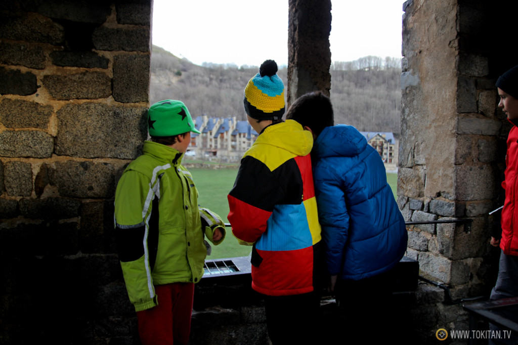 Un grupo de niños, con sus coloridas prendas de esquí, observan desde el campanario de la Iglesia de Saint Climent de Taüll. 